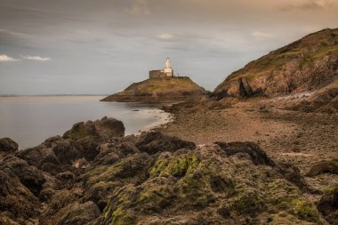 Mumbles Deniz Feneri Swansealow gelgit Swansea Gower yarımadasında Mumbles Deniz Feneri etrafında kayalar teşhir, Güney Galler, İngiltere.