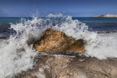 Yunanistan 'ın Kefalonia adasındaki Petani sahilindeki bir kayanın üzerine düşen bir dalga yakalandı,