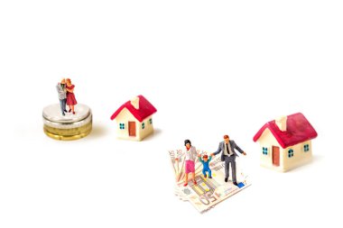 Alışveriş arabası ve alışveriş sepetinin üzerinde duran minyatür aile bireyleri beyaz arka planda izole edilmiş, emlak yönetimi konsepti için görüntü.