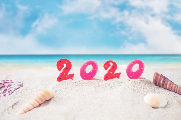 澄んだ青い空と青い海と砂浜の上にカラフルなキャンドル番号2020 新年のための画像2020お祝いの装飾コンセプト — ストック写真