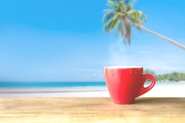 cup of coffee on wooden table over blue sky and sea on day noon light background.