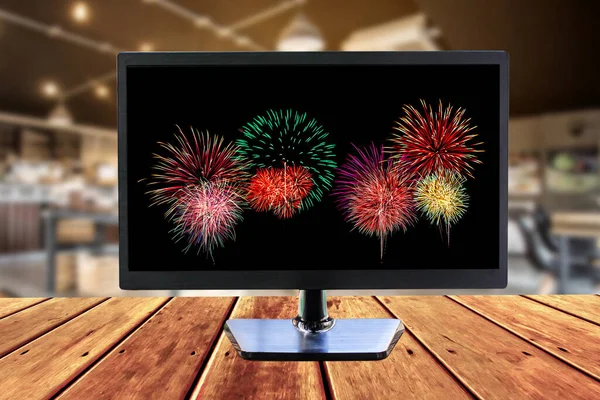 monitor wild screen with firework image on wooden mock-up.