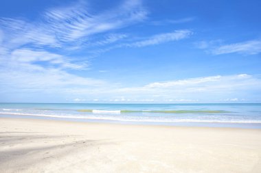 Beyaz kumsal manzarası mavi deniz ve bulutlu mavi gökyüzü arka planı yaz yolculuğu konsepti için..