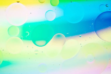 Modern tasarım arka planı için suyun üzerindeki yağ damlasının renkli pastel görüntüsü.