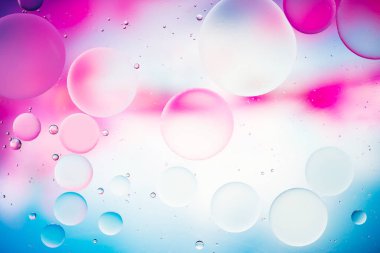 Modern tasarım arka planı için suyun üzerindeki yağ damlasının renkli pastel görüntüsü.