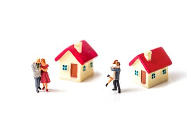 Minyatür aile ve minyatür ev beyaz arka planda izole edilmiş 