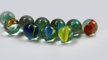 Watch as colorful marbles roll and collide, creating a mesmerizing dance of light and motion, perfect for conveying childhood fun and the joy of simple games.