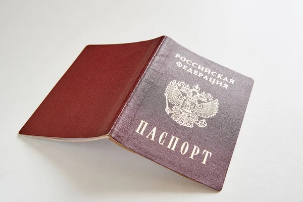 Russian passport on a white table. Russian Federation and Passport is written in Russian.