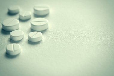 Yakın çekim görünümünü birkaç beyaz hap (tablet). Tonda. Seçici odak.
