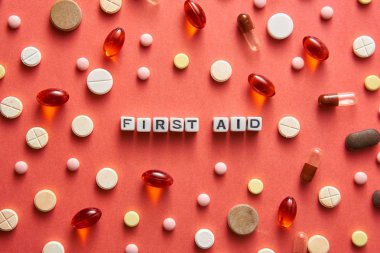 Siyah beyaz başlık Mercan arka plan üzerinde tablet ile masada beyaz küpler İlk Yardım