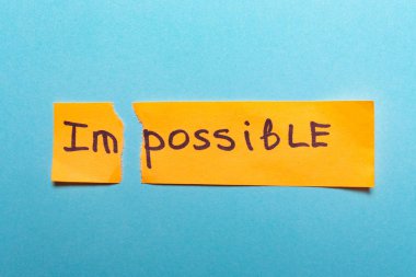 Word imkansız sarı kağıt üzerinde yazılı ve yırtık bir background.success ve meydan okuma kavramı mavi, motivasyon, başarı, hedef