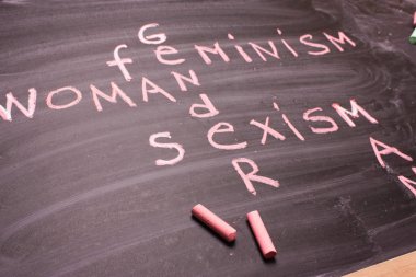 Words gender, sexism, feminism written in pink chalk on a chalkboard clipart