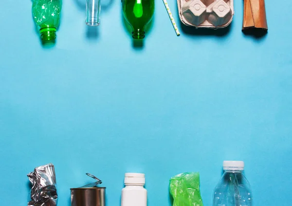 Evin diğer çöplerini attığınız mavi bir arka plan üzerinde. Sıralama kağıt, cam, plastik, polietilen karton kavramı. Çevre koruma
