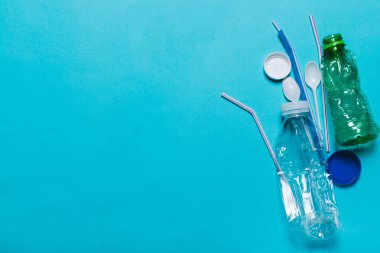 Plastik şişeler, tüpler, kaşık, mavi bir arka plan üzerindeki
