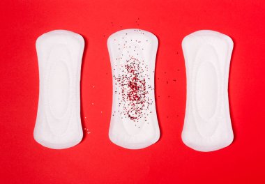 Bir mercan kırmızı kadın arka plan üzerinde üç sıhhi yastıkları. 