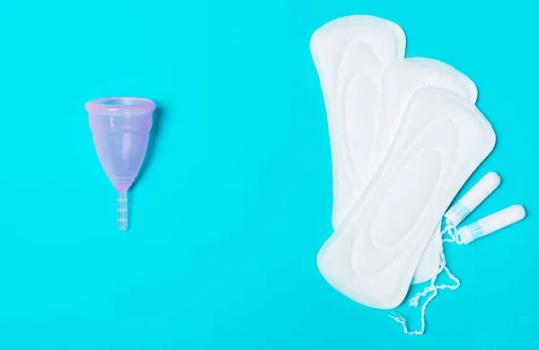 Накладка, менструальна чашка, тампон на синьому фоні . — стокове фото