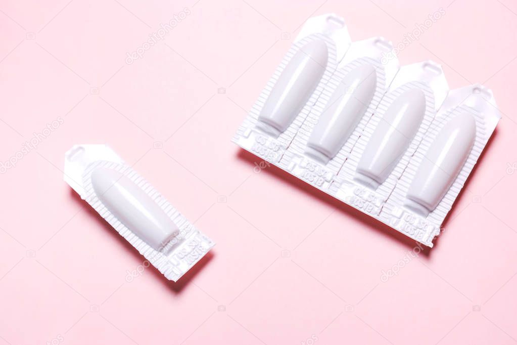 suppository on a pink background, for the treatment of hemorrhoi