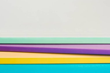 A stack of color notebooks, yellow, purple, green. 