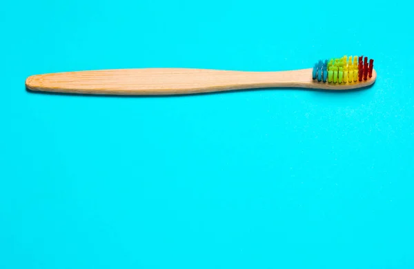 Öko-Bambus-Zahnbürste, organisch auf blauem Hintergrund mit farbigem B — Stockfoto