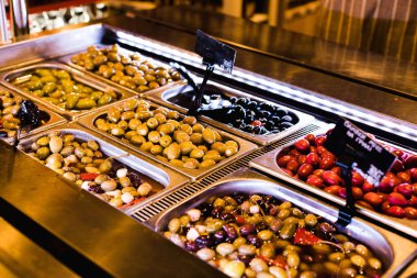 Kaplara doldurulmuş yeşil, kırmızı, siyah zeytinler.