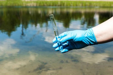 Eldivenli el test tüpünde su topluyor. Ekoloji, çevre kirliliği kavramı