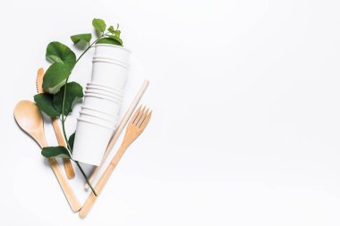 Kağıt bardaklar, tahta çatal, kaşık, bıçak, tüp, beyaz arka plan. Geri dönüşüm, ekoloji, gezegen koruma kavramı, sıfır atık