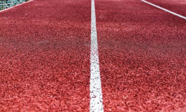 Kırmızı koşu bandının arka planı, stadyum. Beyaz çizgiler, çizgiler