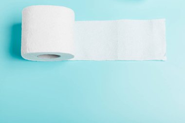 Mavi arka planda beyaz tuvalet kağıdı rulosu. Üst Manzara. Temizlik, temizlik kavramı.