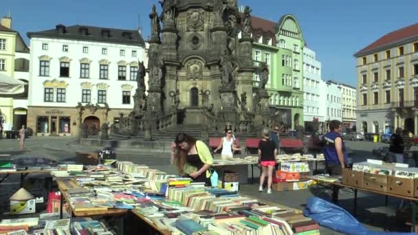 Olomouc, Çek Cumhuriyeti, 30 Nisan 2018: kitaplar arka plan Unesco miras veba sütunu Holy Trinity Olomouc şehir kare pazarı piyasada satışı, insanlar satın alıyor — Stok video