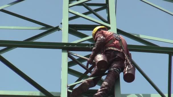 OLOMOUC, REPÚBLICA CHECA, ABRIL 25, 2018: O pintor masculino está pintando um antigo poste de coluna de aço de alta tensão elétrica em vermelho, baldes de tinta e escova, trabalho de altura fisicamente muito exigente — Vídeo de Stock