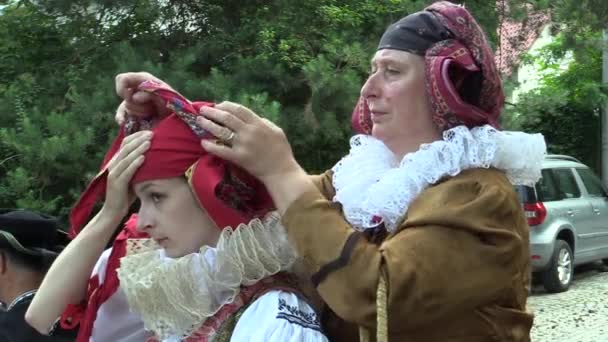 Olomouc, Republika Czeska, 24 maja 2018: pielgrzymka tłum ludzi mężczyźni i kobiety krzyż sposób w tradycyjnym stroju ludowym Hana, Starsza kobieta dostosowuje młodych ladys kostium chustę — Wideo stockowe