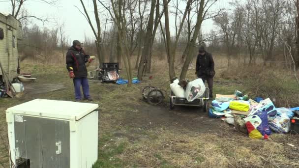 オロモウツ、チェコ共和国、2018 年 3 月 20 日: ホームレスの人々 は運送カートを運ぶプラスチックこみ、木材、電子ケーブル ゴミの収集します。黒廃棄物埋立の生存の瀬戸際での生活 — ストック動画