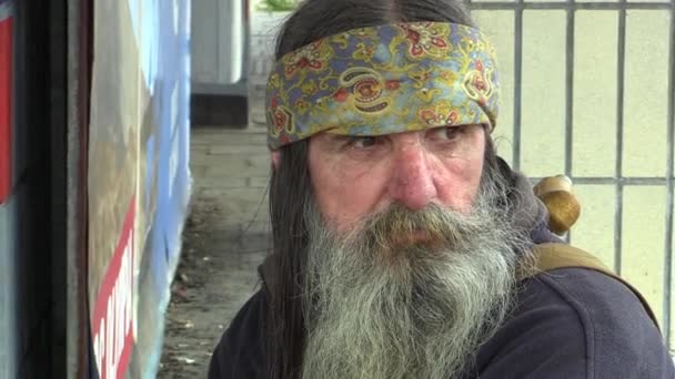 Olomouc, Republika Czeska, 5 maja 2018: autentyczne emocje twarz bezdomnego w miasto, długą brodę i Indian szalik w jej włosy, biedny człowiek na krawędzi społeczeństwa, Europa — Wideo stockowe