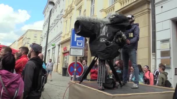 Olomouc, Tjeckien, 23 juni 2018: halvmaraton kör Olomouc 9th, spår city i park professionella kameraman för live stream Tv och internet, kamera och stativ med regnrock — Stockvideo