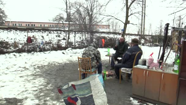 OLOMOUC, REPÚBLICA CHECA, 29 DE ENERO DE 2018: Desamparados y perros quemando y creando fuego para calentarse en la nieve invernal, vías de tren — Vídeo de stock