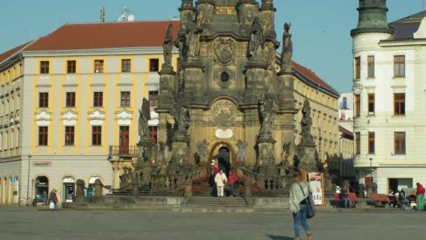 OLOMOUC, REPÚBLICA CHECA, 2 DE OCTUBRE DE 2018: Columna de la Plaga del Patrimonio de la UNESCO Santa Trinidad, la gente camina alrededor de la plaza Horni namesti, monumento arquitectónico nacional cultural y punto de referencia 4K — Vídeo de stock