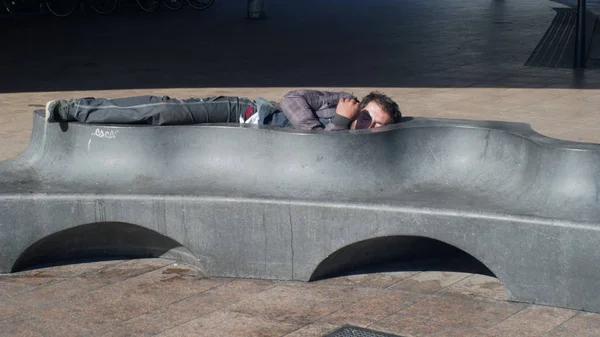 OSTRAVA, REPÚBLICA CHECA, 28 de agosto de 2018: Auténtico vagabundo emocionado dormido en un banco y acera, la vida en las calles de la ciudad y la realidad del día, los pobres y la depresión en la vida — Foto de Stock