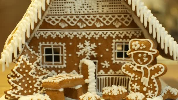 Maison en pain d'épice et gâteau cottage belle, arbre avec maisons et bonhomme de neige, décoré d'une confiserie glaçage blanc avec des blancs d'œufs battus, travail créatif folklorique, période de Noël, neige d'hiver — Video
