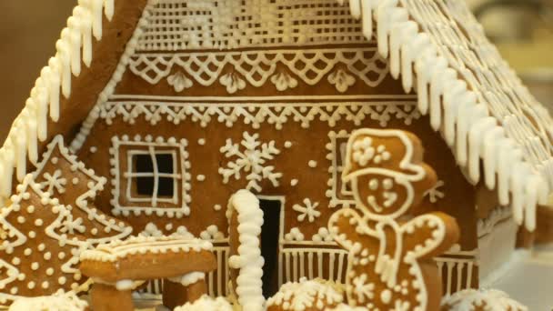Maison en pain d'épice et gâteau cottage belle, arbre avec maisons et bonhomme de neige, décoré d'une confiserie glaçage blanc avec des blancs d'œufs battus, travail créatif folklorique, période de Noël, neige d'hiver — Video