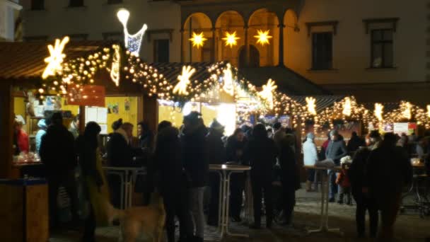 Olomouc, Tsjechië, 20 December, 2018: Kerstmarkten nacht verlichting met versieringen sterren en ornamenten kraam stand met alcohol punch met vruchtensap, mensen kopen drankjes in een kopje — Stockvideo
