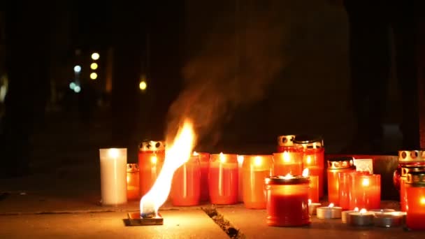 Velas encendidas como monumento a la muerte de un hombre, llamas del fuego ardiente rojo, un lugar en la plaza, un lugar mágico con un mensaje místico de vida para la humanidad y amor al prójimo — Vídeos de Stock