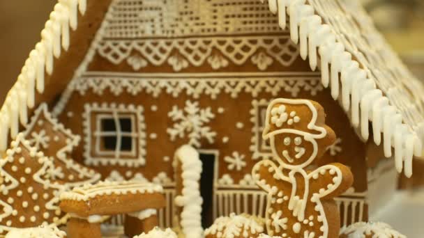 Casa de pan de jengibre y pastel de cabaña hermoso, árbol con casas y muñeco de nieve, decorado con un glaseado blanco de confitería con claras de huevo batidas, trabajo creativo popular, tiempo de Navidad, nieve de invierno — Vídeo de stock