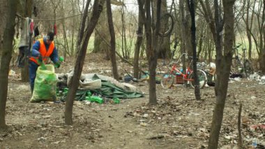Olomouc, Çek Cumhuriyeti, 2 Ocak 2019: Adam toplamak plastik şişe çöp nad çöp toplar torbası, orman manzara nesli tehlike altında olan doğa, insan kir çöp siyah döküm