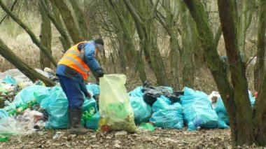 Olomouc, Çek Cumhuriyeti, 2 Ocak 2019: Adam toplamak plastik şişe çöp nad çöp toplar torbası, orman manzara nesli tehlike altında olan doğa, insan kir çöp siyah döküm