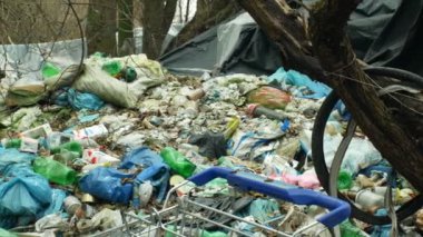 Olomouc, Çek Cumhuriyeti, 2 Ocak 2019: Bi boka yaramaz alışveriş sepeti siyah döküm atık ve çöp kutusu çöp poşetleri manzara orman çöp çöp, yaprak evsiz ahşap plastik folyo chalet ini 4k