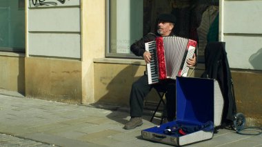Olomouc, Çek Cumhuriyeti, 29 Şubat 2019: Çingene adam parayla bir bardağa otantik müzik akordeon mızıka, kaldırım ve atmak para üzerinde bir dilenci oyun yalvarıyor City