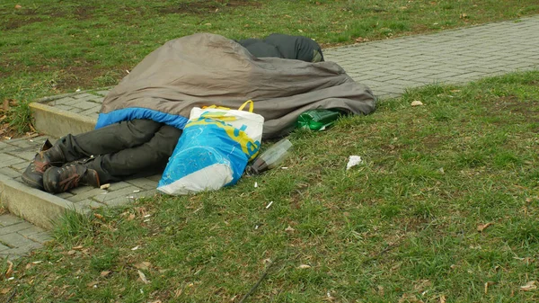 Olomouc, Cseh Köztársaság, 2019. január 2.: hiteles érzelmek hajléktalan ember alszik és az alvás Street közelében áruház bevásárlóközpont bolt, gyaloglás emberek élet város hálózsák — Stock Fotó