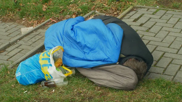 Olomouc, Cseh Köztársaság, 2019. január 2.: hiteles érzelmek hajléktalan ember alszik és az alvás Street közelében áruház bevásárlóközpont bolt, gyaloglás emberek élet város hálózsák — Stock Fotó