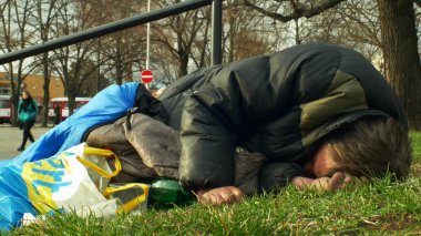 Olomouc, Çek Cumhuriyeti, 2 Ocak 2019: evsiz uyuyor ve uyku tulumu yakınında mağaza alışveriş merkezi Salonu, insanların yaşam Şehir Parkı, otantik duygu yürüyüş sokakta uykusunda
