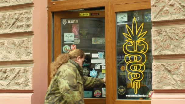 Olomouc, Tjeckien, 2 januari 2019: butik medicinsk hampa cannabis, också säljer fröer produkter, skyltfönster butik med cannabis marijuana symboler, människor går in i butiken, försäljning av bong — Stockvideo